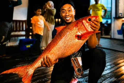 Encik Muhammad Haziq Sulaiman, menunjukkan ikan kakap merah atau ruby snapper seberat 17 kilogram.