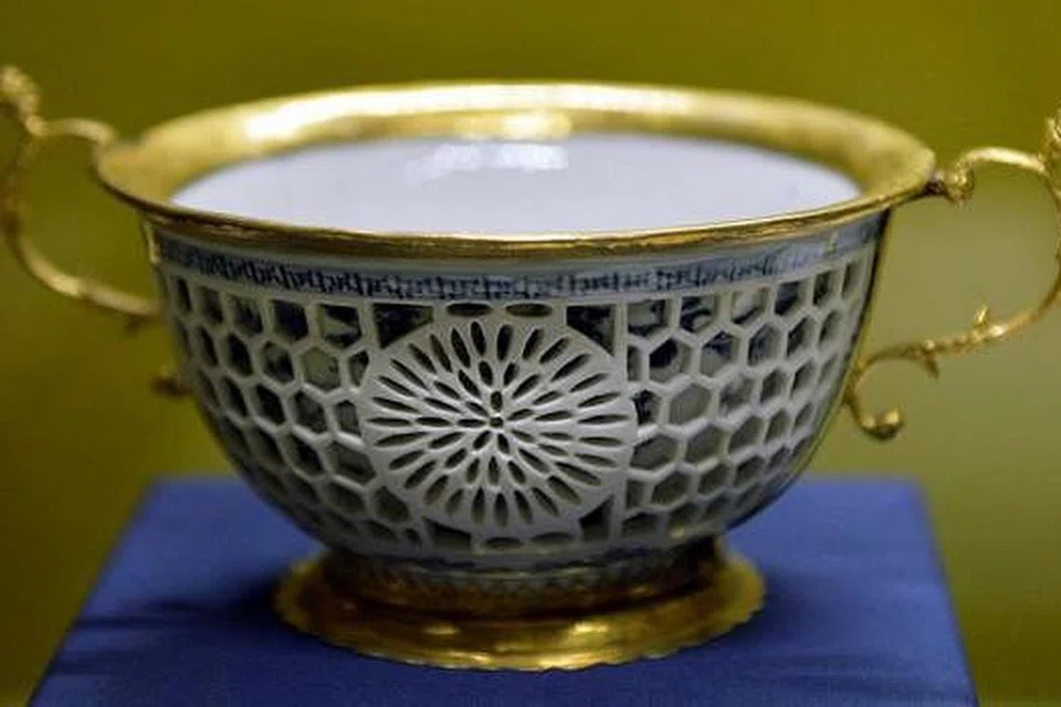  MANGKUK TEBUKAN BERBINGKAI: Karya tembikar ini dibuat di Jingdezhen, China, pada akhir kurun ke-17. Ia dihasilkan menggunakan teknik khas dan mempunyai dua lapisan, bahagian luar ditebuk dengan corak bunga api dan kekisi. Bingkai bersalut perak ditambahkan di Belanda bagi memberi fokus pada bahagian tembikarnya. 