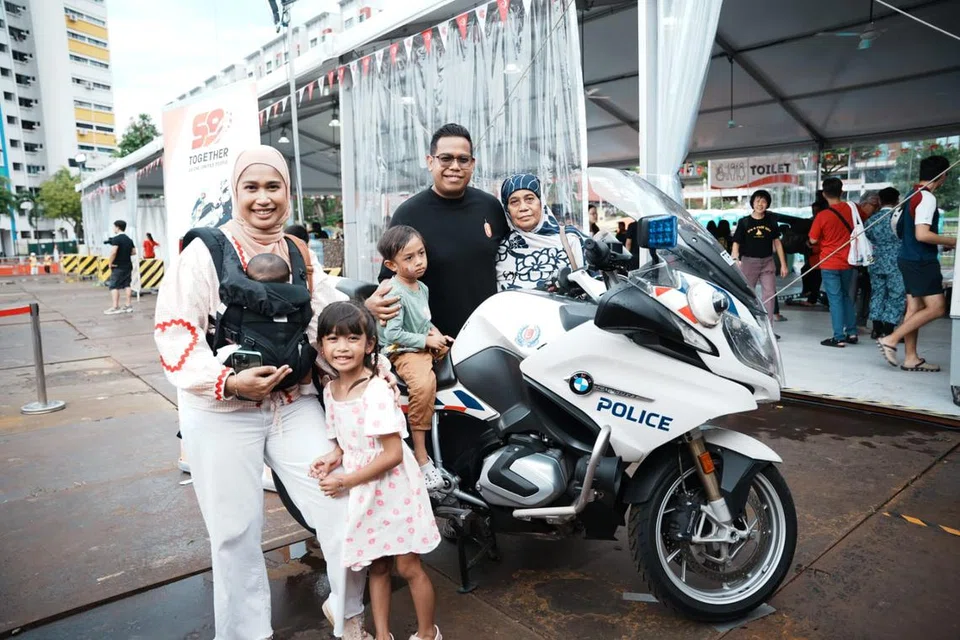 Encik Saiful Azzam Salleh (dua dari kanan) bersama adiknya Cik Syafiqah Salleh (kiri) dan ibunya, Cik Saodah Ibrahim (kanan) yang turut berada di padang terbuka bersebelahan Paya Lebar Quarter 1.  Anak saudara Encik Saiful, Anissa Nawrah Jumali (dua dari kiri) dan Anas Nuwayr Jumali (tengah) bergambar bersama motosikal Pasukan Polis Singapura (SPF). 