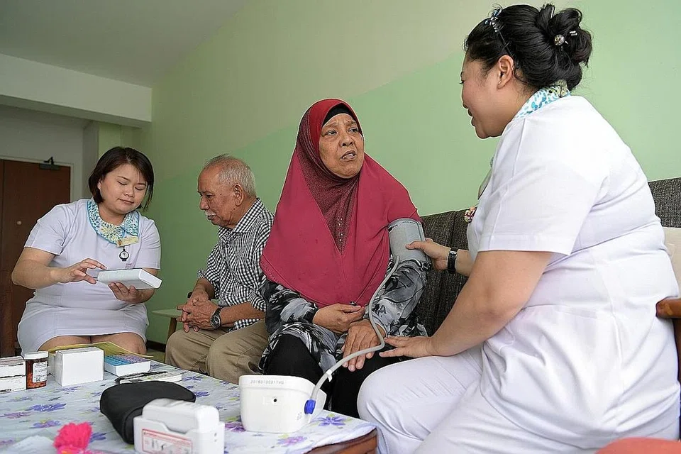 BUAT KUNJUNGAN KE RUMAH: Jururawat staf kanan Cik Phyllis Tan Sze Hui (kiri) menerangkan ubat-ubatan yang perlu diambil oleh Encik Sarif Mohamad (dua dari kiri) sementara tekanan darah isterinya, Cik Mariam Bee Tahir (dua dari kanan) diambil oleh seorang lagi jururawat kanan, Cik Mawarni Arof. - Foto BH oleh NG SOR LUAN