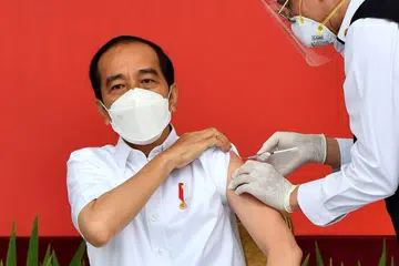 ORANG PERTAMA DI INDONESIA TERIMA VAKSIN: Presiden Jokowi menjadi penerima pertama vaksin Covid-19 dalam usahanya meyakinkan penduduk Indonesia bahawa vaksin itu bukan sahaja selamat dan berkesan, bahkan halal buat Muslim. - Foto REUTERS