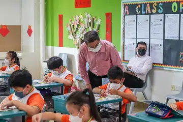 MENDEKATI KANAK-KANAK: Dr Faishal (berdiri) menyertai aktiviti kelas di Sekolah Rendah Palm View semalam pagi, di mana murid mempelajari mengenai keganasan keluarga melalui buku 'A Day with Bob'. - Foto SPF