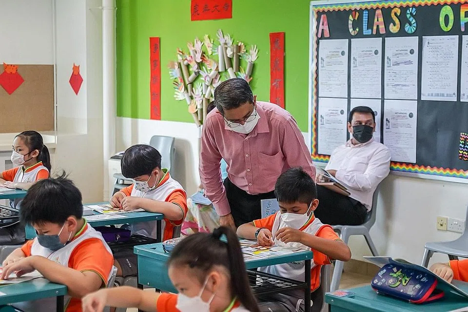 MENDEKATI KANAK-KANAK: Dr Faishal (berdiri) menyertai aktiviti kelas di Sekolah Rendah Palm View semalam pagi, di mana murid mempelajari mengenai keganasan keluarga melalui buku 'A Day with Bob'. - Foto SPF