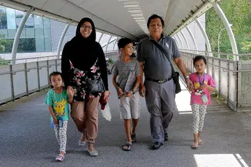 SOKONGAN KELUARGA: Encik Jaafar ditemani anak sulungnya, Cik Jamaliah Jaafar, serta cucu-cucunya, (dari kanan) Alya Qalesya Hatmide, Zulhaziq Hatmide dan Hasya Farisah Hatmide, semasa pergi bertemu ahli farmasi. - Foto KHALID BABA