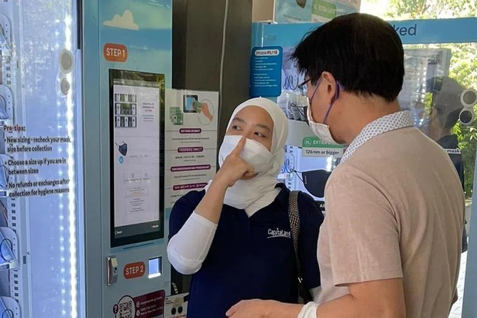 MEMBERI KEMBALI KEPADA MASYARAKAT: Sebagai duta #StayMasked, Cik Saudah dikerahkan di Bukit Panjang Plaza untuk membantu ramai memilih pelitup yang sesuai mengikuti ukuran yang betul. - Foto CAPITALAND.