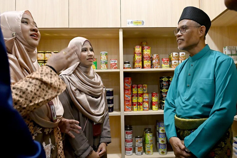 Selepas menunaikan solat Hari Raya Aidilfitri sesi pertama di Masjid Al-Iman pada 31 Mac, Menteri Bertanggungjawab bagi Ehwal Masyarakat Islam, Encik Masagos Zulkifli Masagos Mohamad (kanan), diberi taklimat tentang inisiatif masyarakat masjid yang telah menyediakan bantuan barangan makanan kepada lebih 250 keluarga tanpa mengira bangsa atau agama yang memerlukan sejak ia dirasmikan pada Ogos 2022.