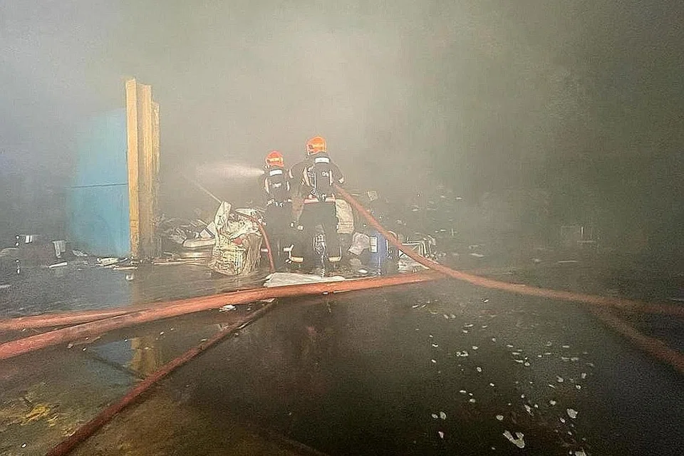 PADAM API: Anggota bomba cuba memadamkan kebakaran yang berlaku di kawasan perindustrian di Tuas South Street 15 awal pagi semalam, sedang asap tebal menyelubungi kawasan tersebut. - Foto SCDF