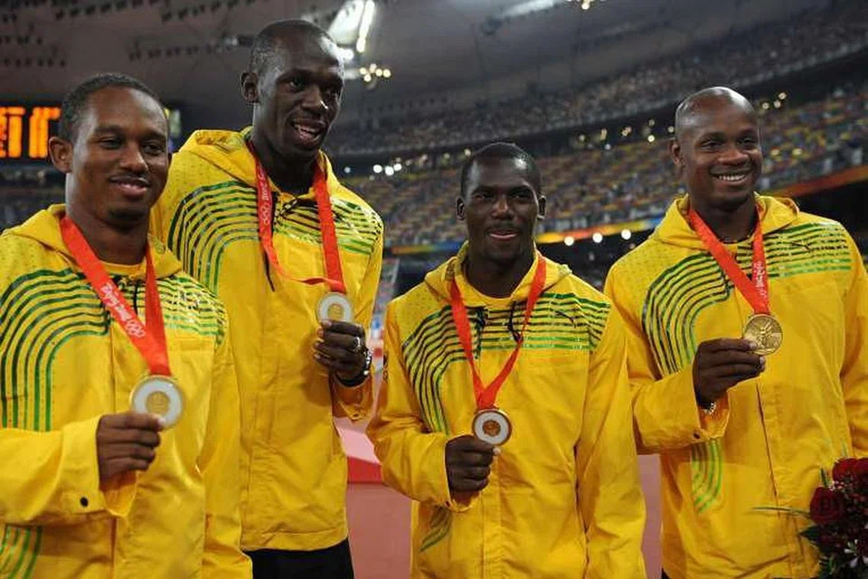 Gambar 2008 menunjukkan Usain Bolt dan rakan pasukan larian berganti-ganti Michael Frater, Asafa Powell dan Nesta Carter, dengan pingat emas mereka. 