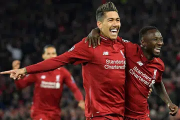 PUAS: Penyerang Liverpool, Roberto Firminho, dan pemain tengah kelab itu, Naby Keita (kanan), meraikan kemenangan mereka di depan penyokong kelab selepas Firmonho berjaya menjaringkan gol kedua Liverpool pada minit ke-26 semasa berdepan dengan kelab Porto bagi pusingan pertama suku akhir Liga Juara-Juara Eropah semalam. - Foto AFP