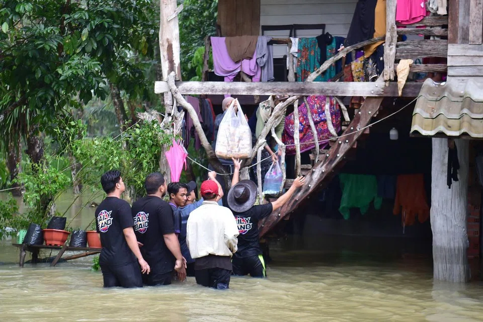 Sukarelawan mengagihkan bekalan makanan kepada penduduk yang terjejas banjir di daerah Mueang, wilayah selatan Narathiwat, Thailand, pada 30 November. 