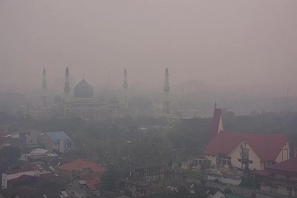 DISELAPUTI JEREBU: Sebuah masjid dan gereja kelihatan samar-samar akibat diselaputi jerebu yang berpunca daripada kebakaran hutan di Pekanbaru, Riau, Indonesia. - Foto REUTERS 