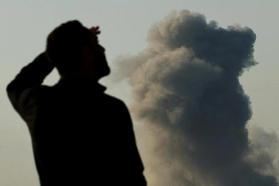 Seorang tentera Israel berlatar asap tebal yang menjulang di Beit Hanoun, Gaza, di tengah-tengah konflik yang berterusan antara Israel dengan Hamas, seperti yang kelihatan dari selatan Israel, pada 8 Januari.
