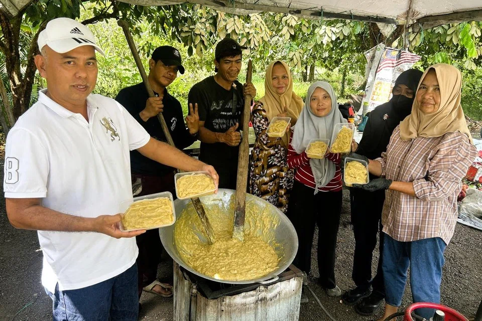 Pemilik Ladang SK Durian di Pekan Nenas, Encik Samsul Kamarudin (kiri), bersama kakitangannya menyiapkan lempuk durian yang menjadi permintaan hangat warga Singapura.