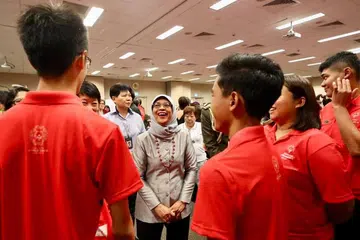 BERI SOKONGAN: Puan Halimah bercakap dengan beberapa atlit Team Singapore yang bersemangat beraksi di Sukan Olimpik Khas Musim Panas Sedunia yang akan bermula pada 14 Mac. 