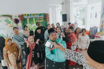 Encik Muhammad Rakin Abdul Rashid (tengah), telah memuat naik beberapa video di TikTok yang menggambarkan kemeriahan suasana keluarga besarnya menyambut Hari Raya di kolong Blok 894C, Woodlands Drive 50.
