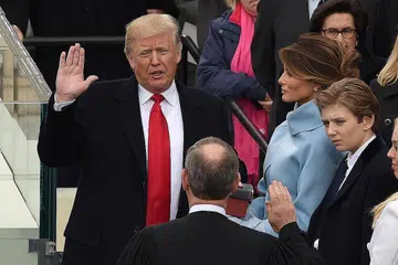 PRESIDEN KE-45: Encik Donald Trump, mengangkat sumpah sebagai Presiden baru Amerika Syarikat semalam, dengan disaksikan isterinya, Cik Melania. - Foto AFP