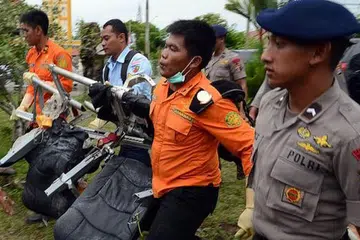 KUMPULKAN SERPIHAN: Beberapa anggota Agensi Mencari dan Menyelamat Nasional Indonesia (Basarnas) membawa kerusi penumpang pesawat AirAsia QZ8501 di Pangkalan Bun untuk diperiksa. - Foto AFP 