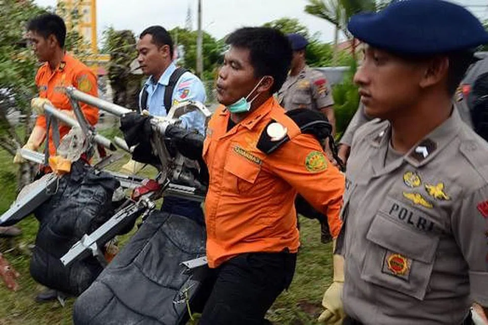 KUMPULKAN SERPIHAN: Beberapa anggota Agensi Mencari dan Menyelamat Nasional Indonesia (Basarnas) membawa kerusi penumpang pesawat AirAsia QZ8501 di Pangkalan Bun untuk diperiksa. - Foto AFP 