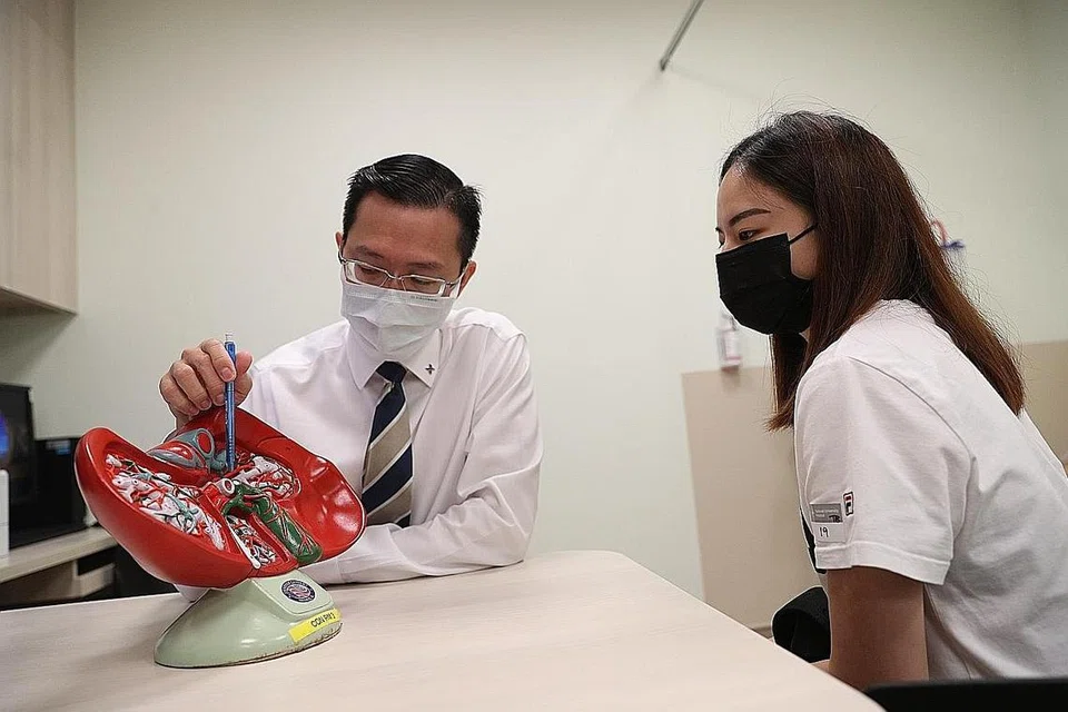 LEBIH RAMAI DIHARAP BANTU: Profesor Alfred Kow menunjukkan model hati kepada seorang penderma, Cik Sophia Chua. Dengan prosedur baru itu, diharapkan lebih ramai orang membantu pesakit memerlukan hati. - Foto BH oleh TIMOTHY DAVID