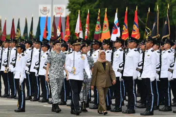 TINJAU PERBARISAN: Presiden Halimah Yacob meninjau kontinjen Kawalan Kehormatan pada Perbarisan Hari SAF yang diadakan di Institut Tentera SAFTI (SAFTI MI).