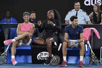BERJENAKA SAMBIL BERAMAL: Serena Williams (tengah) bergurau dengan Rafael Nadal (kiri) dan Novak Djokovic (kanan) dalam pertandingan amal yang bertujuan membantu mangsa kebakaran belukar Australia. - Foto AFP