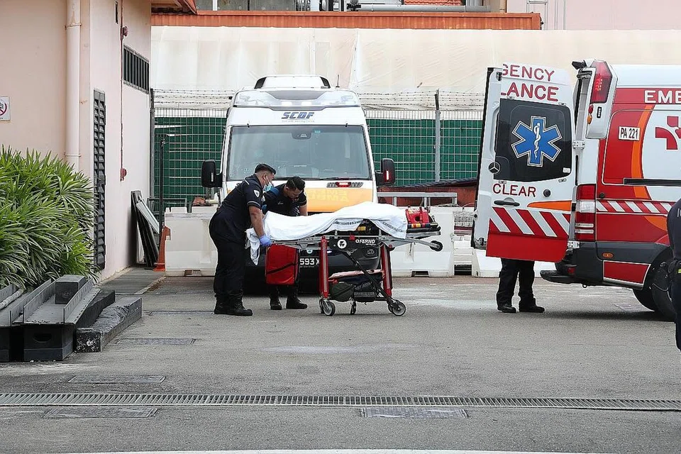 DIPINDAHKAN: Seorang pegawai Mendaki yang cedera diusung memasuki ambulans setelah tiba di Terminal Feri Tanah Merah semalam. - Foto BH oleh TIMOTHY DAVID, MONTIGO RESORTS