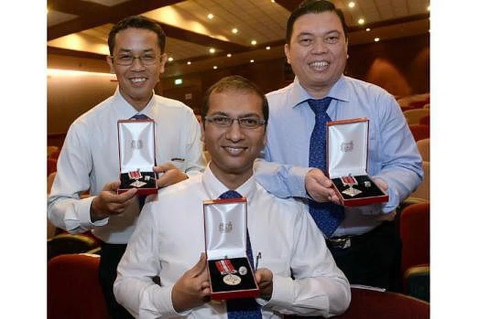 DIIKTIRAF: (Dari kiri) Encik Mohd Aidilreza Abdul Aziz, Encik Mohamed Jabar Sadiq Basha dan Encik Hussin Osman menerima Anugerah Hari Kebangsaan Kementerian Pembangunan Negara (MND) di pejabat kementerian itu di Maxwell Road Jumaat lalu. - Foto TAUFIK A. KADER