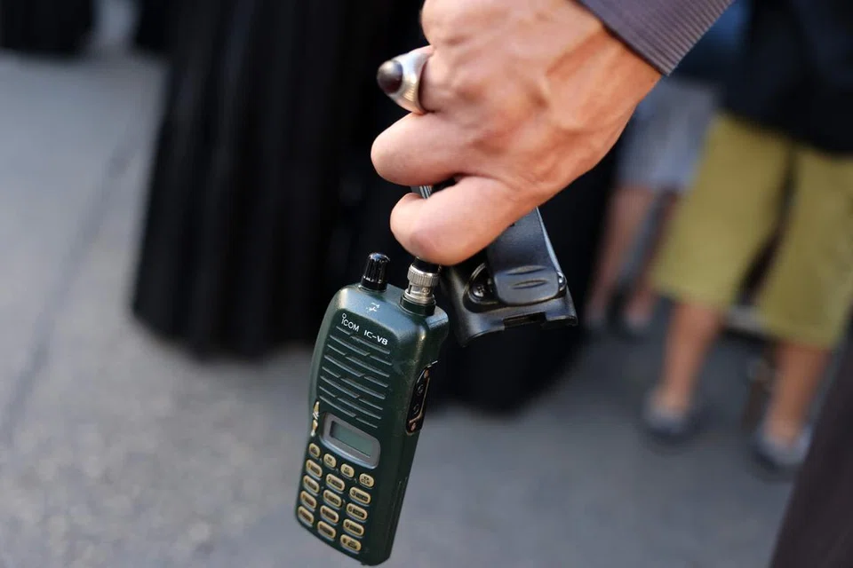 Seorang lelaki memegang alat ‘walkie talkie’ yang dikeluarkan bateri semasa pengebumian mangsa setelah beratus-ratus peranti alat kelui dan ‘walkie talkie’ meletup dalam gelombang maut di seluruh Lebanon pada 17 dan 18 September.
