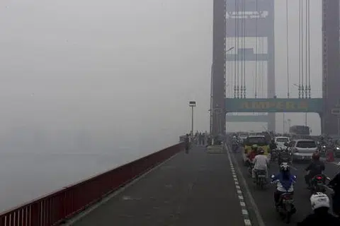 BUKAN DILITUPI KABUS: Jambatan Ampera, yang digunakan kenderaan dan pejalan kaki untuk menyeberangi Sungai Musi di Palembang, di wilayah Selatan Sumatera, Indonesia, diselubungi jerebu sejak beberapa hari lalu. - Foto REUTERS