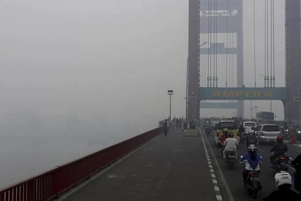 BUKAN DILITUPI KABUS: Jambatan Ampera, yang digunakan kenderaan dan pejalan kaki untuk menyeberangi Sungai Musi di Palembang, di wilayah Selatan Sumatera, Indonesia, diselubungi jerebu sejak beberapa hari lalu. - Foto REUTERS
