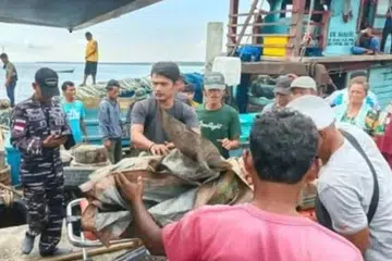 Kru yang diselamatkan daripada bot nelayan yang terbakar tiba di Pelabuhan Belawan di Medan, Sumatera Utara, pada 7 April.