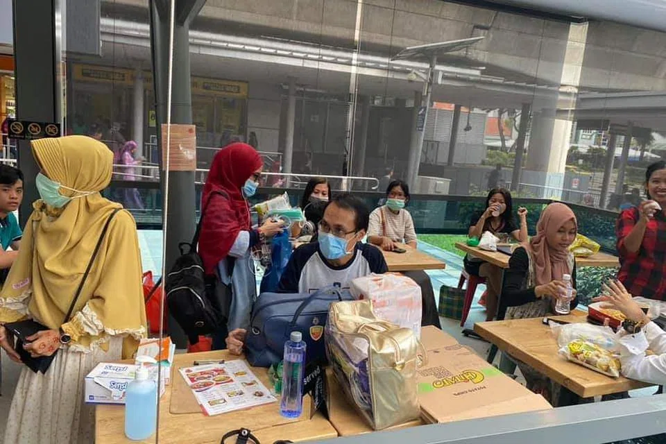 GOTONG-ROYONG: Beberapa warga Indonesia bergotong-royong membahagi-bahagikan pelitup dan snek kepada orang ramai di kawasan Payar Lebar pada Ahad (9 Februari).