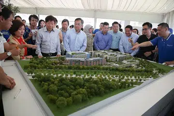 MENINJAU MODEL KAMPUS KESIHATAN WOODLANDS (WHC): Menteri Kesihatan Gan Kim Yong (di tengah, berbaju biru cair dan berkaca mata) melihat model WHC, dengan disaksikan Menteri Pengangkutan Khaw Boon Wan (di kanannya), Setiausaha Parlimen (Ehwal Dalam Negeri) Amrin Amin, yang juga Anggota Parlimen GRC Sembawang (tiga dari kanan), dalam acara pecah tanah yang turut dihadiri Speaker Parlimen Halimah Yacob, yang juga Anggota Parlimen (AP) GRC Marsiling-Yew Tee (bertudung). Kampus seluas kira-kira 11 padang bola sepak dan terletak berdekatan Masjid Yusof Ishak di Woodlands Drive 17 itu akan menerima pesakit pertama pada 2022. - Foto THE STRAITS TIMES
