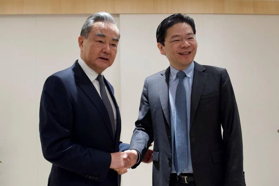 PERTINGKAT KERJASAMA: Timbalan Perdana Menteri, Encik Lawrence Wong (kanan), turut bertemu Encik Wang Yi, yang juga Pengarah Pejabat Suruhanjaya Pusat Ehwal Luar China. 