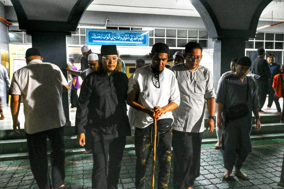 Vokalis kumpulan rok ikonik, Ali XPDC (tengah), yang dipapah dua sahabat berada di Masjid Bandar Baru Salak Tinggi, di Sepang, Malaysia, untuk menunaikan solat jenazah isterinya, Allahyarhamha Sharifah Azuwanna Syed, yang meninggal dunia pada 6 April akibat barah buah dada.
