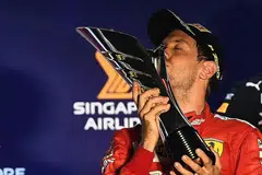 KEMENANGAN MANIS: Vettel mencium piala kemenangan Grand Prix Singapura kelimanya. Pemandu Red Bull Max Verstappen (tiada dalam gambar) mengakhiri perlumbaan di posisi ketiga. - Foto BH oleh EPA-EFE.