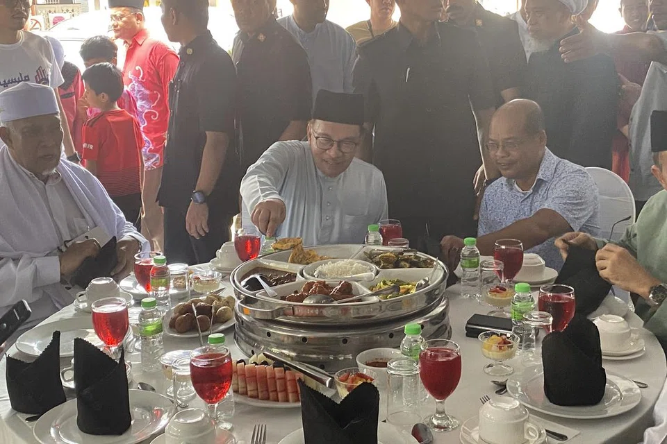 MENJAMU SELERA DENGAN PEMIMPIN DAN RAKYAT: Datuk Seri Anwar Ibrahim meluangkan masa menjamu selera dengan beberapa pemimpin PH-BN dan penduduk setempat selepas mendirikan solat Jumaat di Masjid Sultan Muhammad di Kuala Terengganu pada 28 Julai.