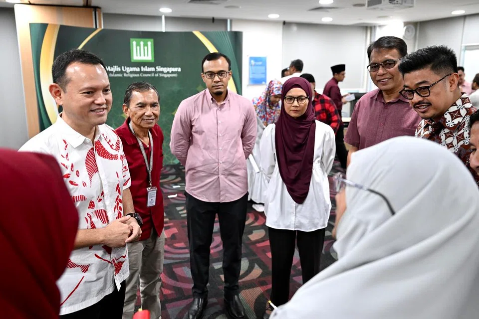 Pemangku Menteri Bertanggungjawab bagi Ehwal Masyarakat Islam merangkap Menteri Negara Kanan (Pertahanan), Encik Zaqy Mohamad (kiri), dan Pemimpin Kanan MUIS beramah-tamah dengan anggota Majlis MUIS.