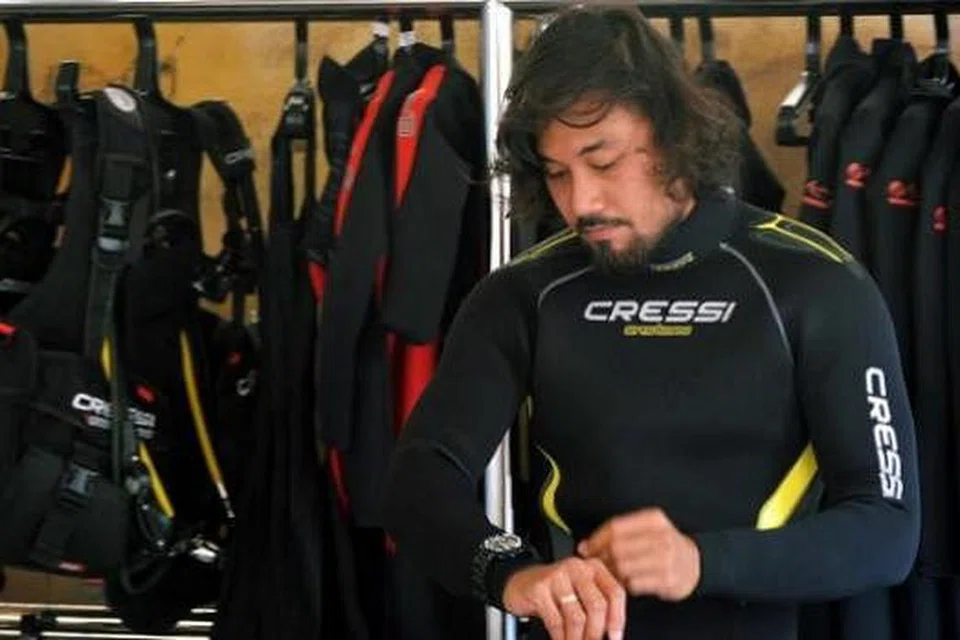 PAKAIAN SELAM: Encik Salleh memakai pakaian yang juga dapat melindungi tubuhnya semasa sesi selam.