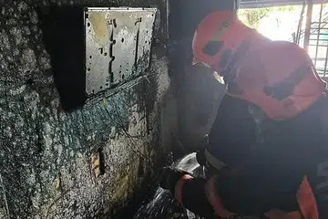 MEMADAMKAN API: Anggota bomba dari Balai Bomba Central memadamkan api menggunakan jet air dan dua beg galas berisi busa udara mampat. - Foto SCDF