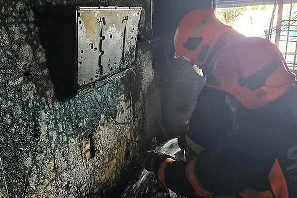 MEMADAMKAN API: Anggota bomba dari Balai Bomba Central memadamkan api menggunakan jet air dan dua beg galas berisi busa udara mampat. - Foto SCDF
