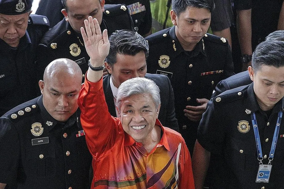 BUKAN PETANDA BAIK: Zahid melambai kepada penyokong semasa tiba di mahkamah untuk menghadapi tuduhan. Presiden menghadapi tuduhan rasuah bukan petanda baik bagi Umno yang cuba menjauhkan dirinya daripada dakwaan rasuah meluas. - Foto EPA-EFE