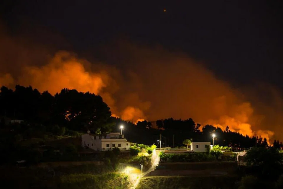 KEBAKARAN TANAH GERSANG: Api dan asap tebal akibat kebakaran hutan boleh dilihat dari perkampungan Valleseco di Gran CanariA di Kepulauan Canary, Sepanyol. -Foto REUTERS.