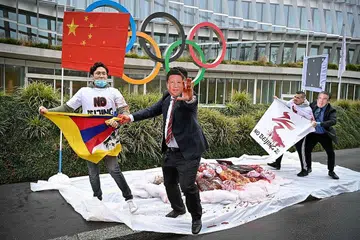 BUAT BANTAHAN: Para penunjuk perasaan memakai topeng dengan wajah Presiden China, Encik Xi Jinping (tengah) dan Presiden IOC, Encik Thomas Bach, berlagak seakan mahu bergaduh semasa satu bantahan terhadap pelaksanaan Olimpik Musim Sejuk Beijing pada 2022 kelak. Sesi bantahan itu diketengahkan sekumpulan aktivis dari Rangkaian Antarabangsa Tibet pada 3 Februari lalu di depan ibu pejabat IOC di Lausanne, Switzerland. - Foto AFP