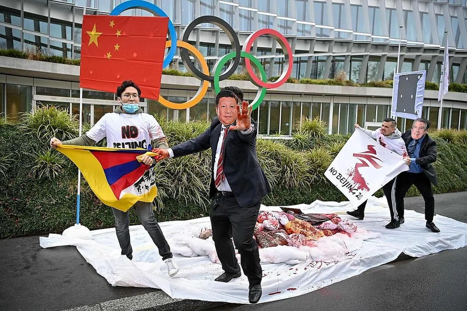 BUAT BANTAHAN: Para penunjuk perasaan memakai topeng dengan wajah Presiden China, Encik Xi Jinping (tengah) dan Presiden IOC, Encik Thomas Bach, berlagak seakan mahu bergaduh semasa satu bantahan terhadap pelaksanaan Olimpik Musim Sejuk Beijing pada 2022 kelak. Sesi bantahan itu diketengahkan sekumpulan aktivis dari Rangkaian Antarabangsa Tibet pada 3 Februari lalu di depan ibu pejabat IOC di Lausanne, Switzerland. - Foto AFP