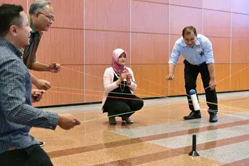 PERKUKUH JALINAN: Para karyawan yang hadir dalam sesi pelan kerja M3@Bandar Jurong sedang melakukan aktiviti yang dapat menyemarakkan lagi semangat berpasukan dalam kumpulan itu. Turut mengambil bahagian dalam aktiviti ini termasuk Cik Rahayu Mahzam (tengah), Encik Muhd Faizal Othman (kanan) dan Encik Sujimy Mohamad (dua dari kiri). - Foto BM oleh NG SOR LUAN