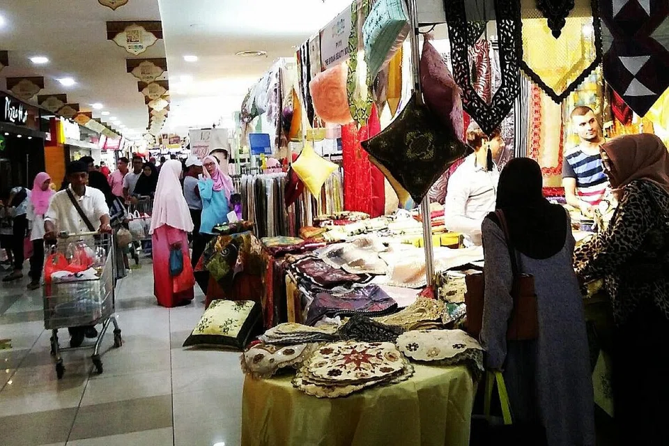 SUASANA AIDILFITRI SEMAKIN TERASA: Pusat beli-belah Angsana Mall menjadi tumpuan warga Singapura yang datang membeli pakaian, persiapan dan hiasan Raya.