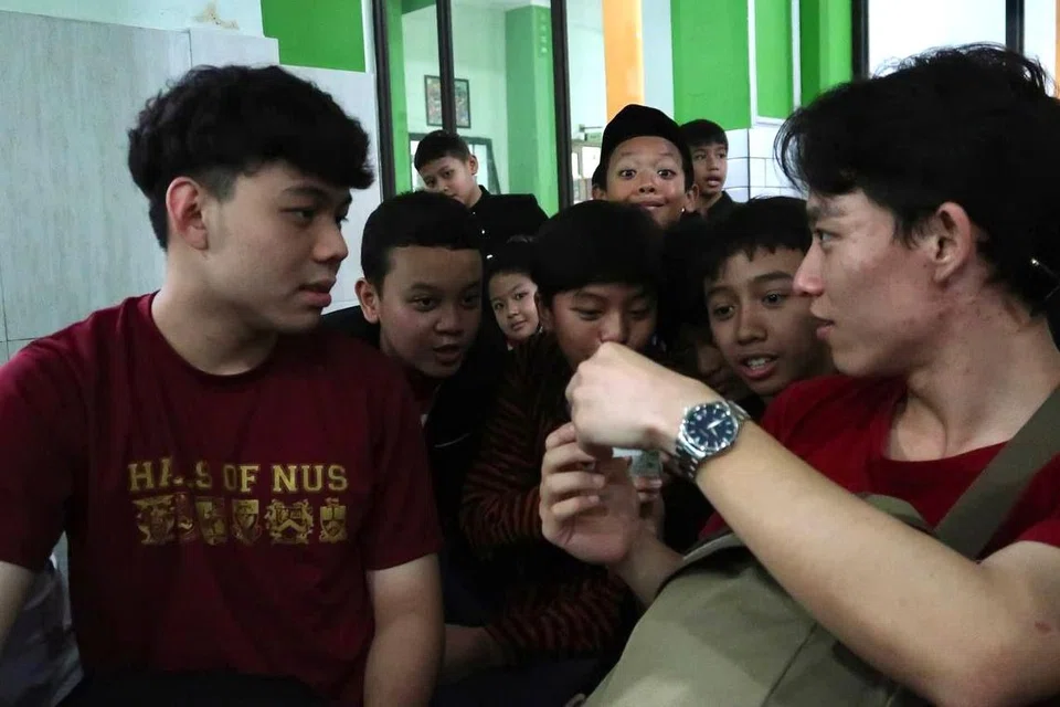 Siswa Universiti Nasional Singapura (NUS), Encik Ivan Seow (kiri) dan Encik Kang Yi Jin, berinteraksi dengan kanak-kanak Madrasah Ibtidaiyah Negeri (MIN) 1 Kota Malang sebagai usaha mendalami kerencaman sistem pendidikan di Malang, dalam lawatan Usaha Persaudaraan Asia Tenggara (SFI) Malang 2025.