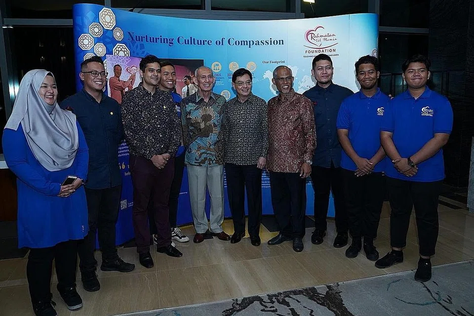 SEDEKAD BERBAKTI Encik Heng dan Encik Masagos (lima dan empat dari kanan) bersama sukarelawan RLAF di sambutan ulang tahun ke-10 yayasan itu semalam. Turut hadir ialah Pengerusi RLAF, Encik Po'ad Mattar (kanan Encik Heng). - Foto BH oleh NUR DIYANA TAHA