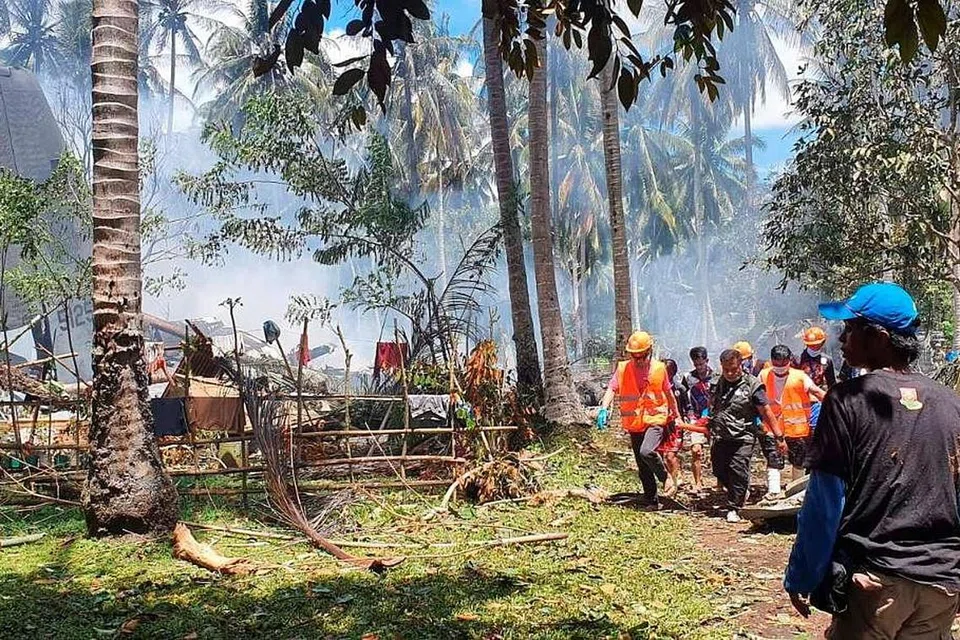 USAHA MENYELAMAT: Kakitangan penyelamat mengusung mangsa pesawat pengangkutan tentera Filipina yang terhempas sewaktu cuba mendarat di Lapangan Terbang Jolo, Pulau Sulu, semalam. - Foto REUTERS
